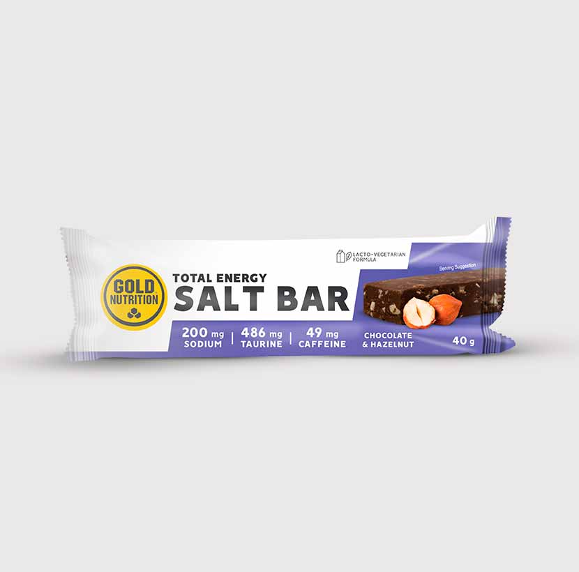 Barra energética GoldNutrition Energy Salt Bar sabor chocolate e amendoim, com 19g de hidratos de carbono, 50mg de cafeína e 203mg de sódio, embalada em fundo preto e verde.	